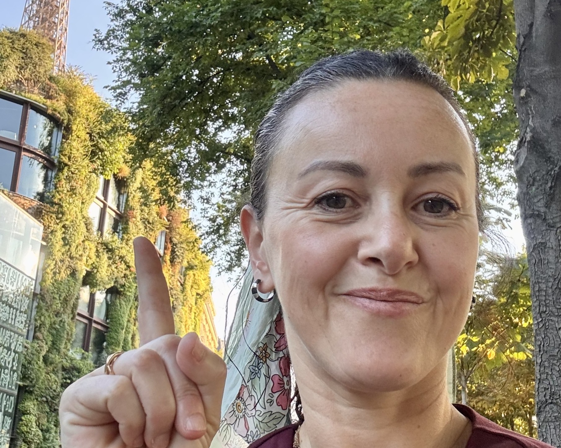 Woman's portrait where she's pointing to a green wall